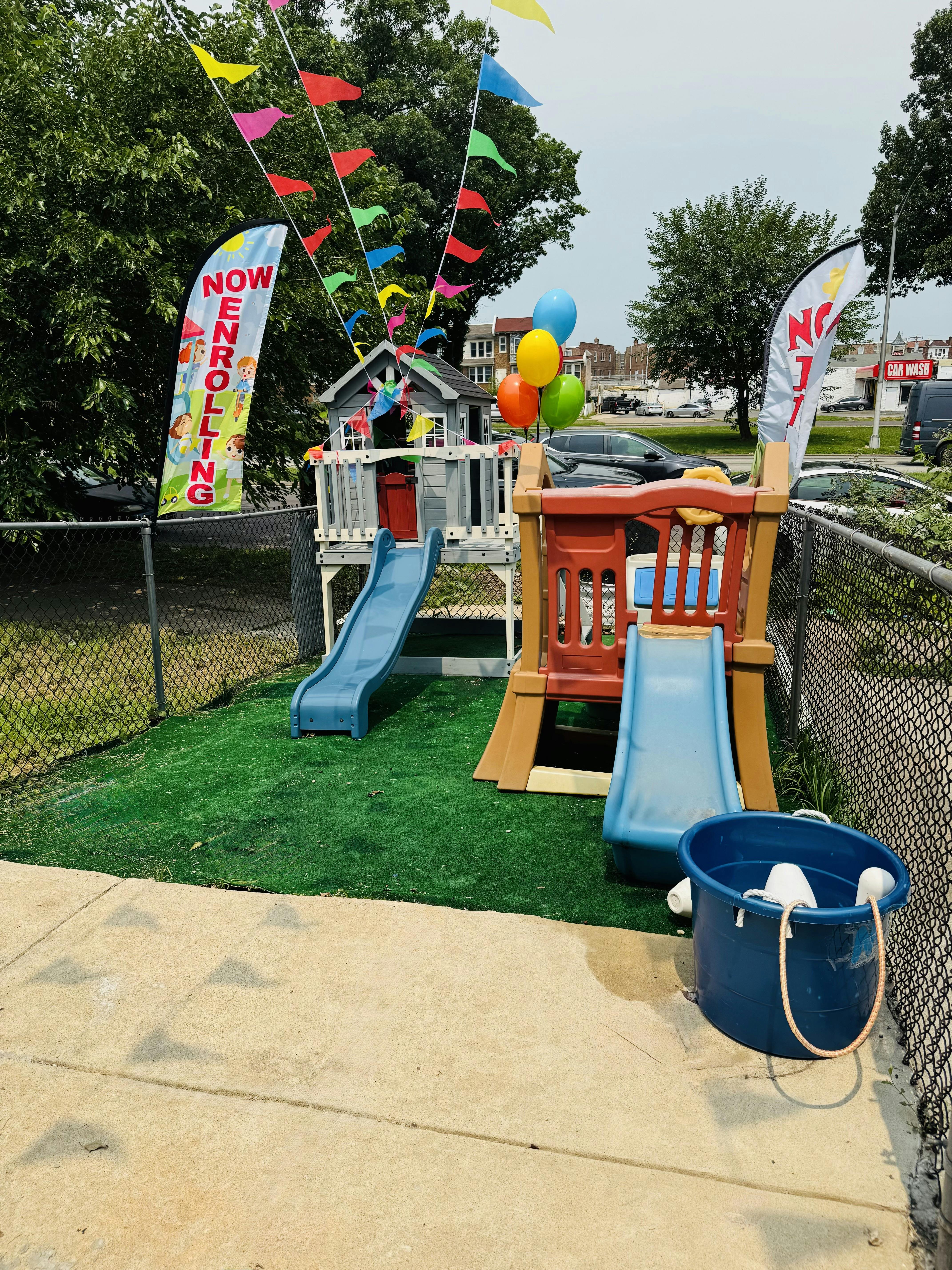 Playground equipment with banners reading now enrolling