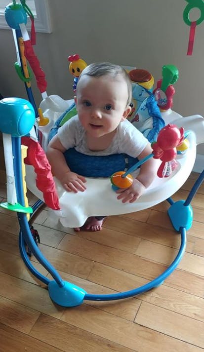 Child in a baby bouncer with toys