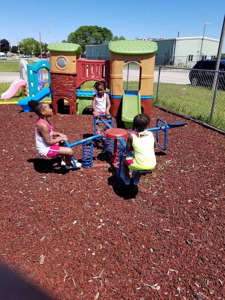 Three children playing on a seesaw at a playground