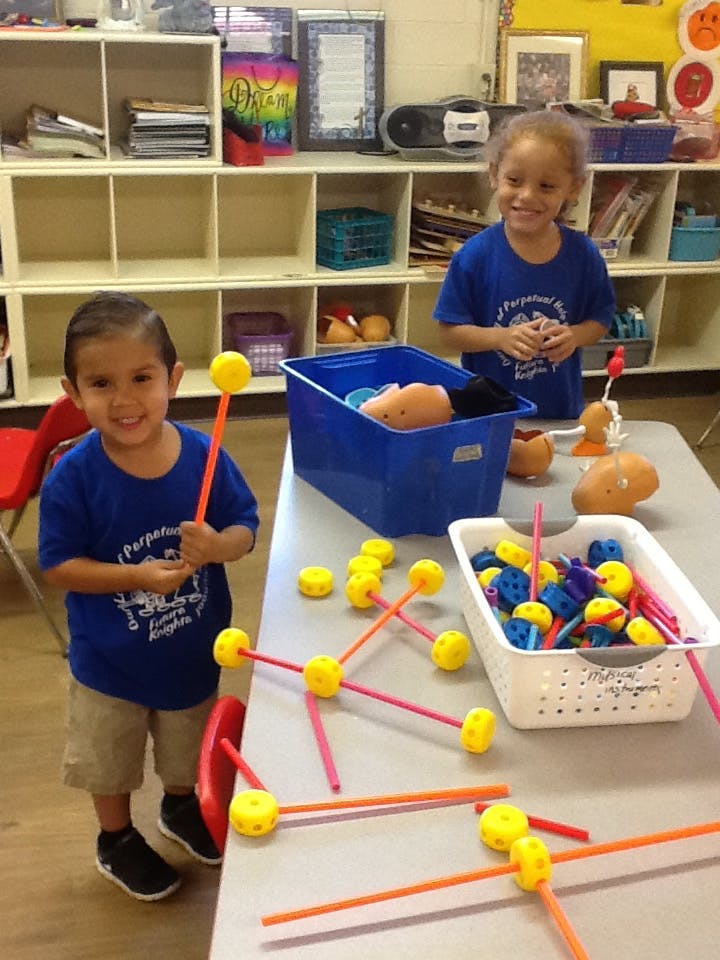 Two children playing with building toys at a table