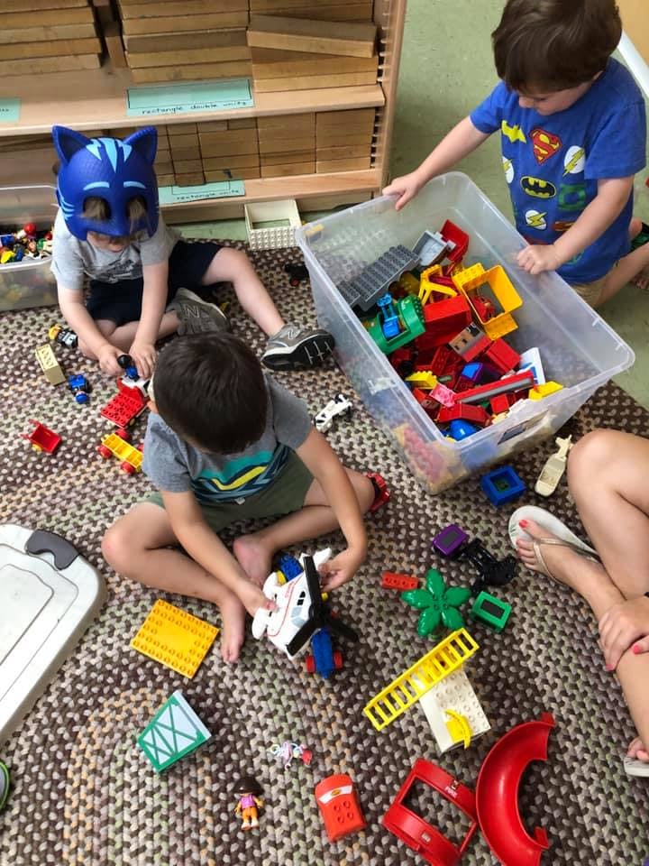 Children playing with building blocks on a rug