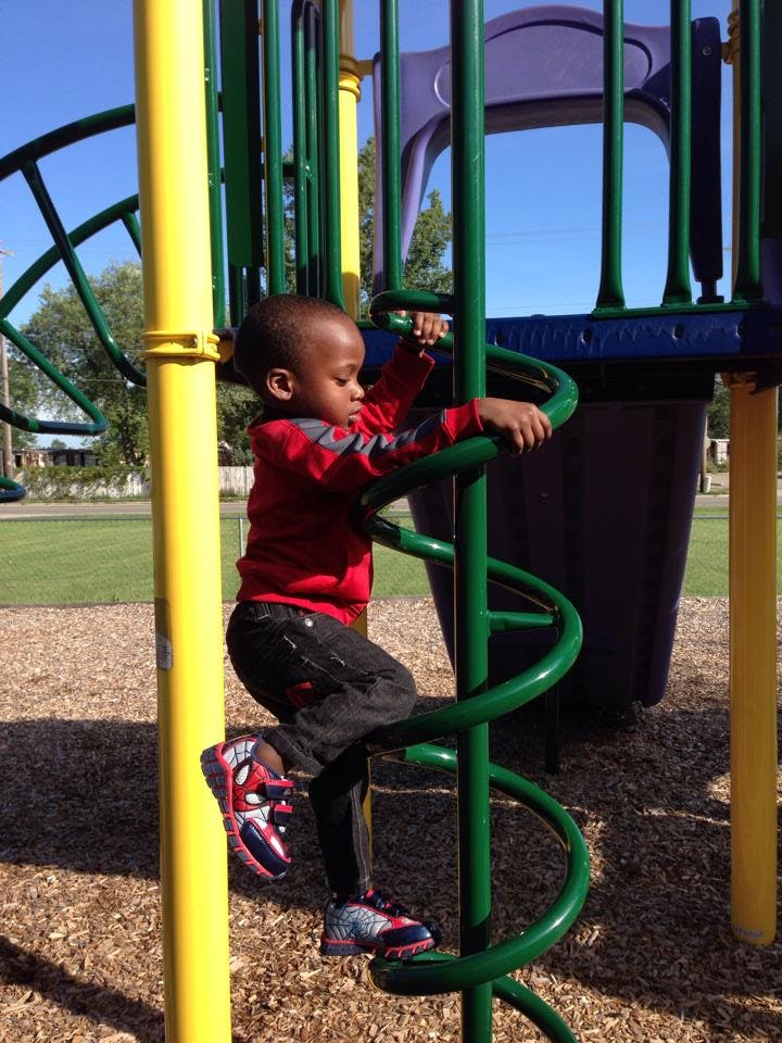 Child climbing a spiral pole on a playground