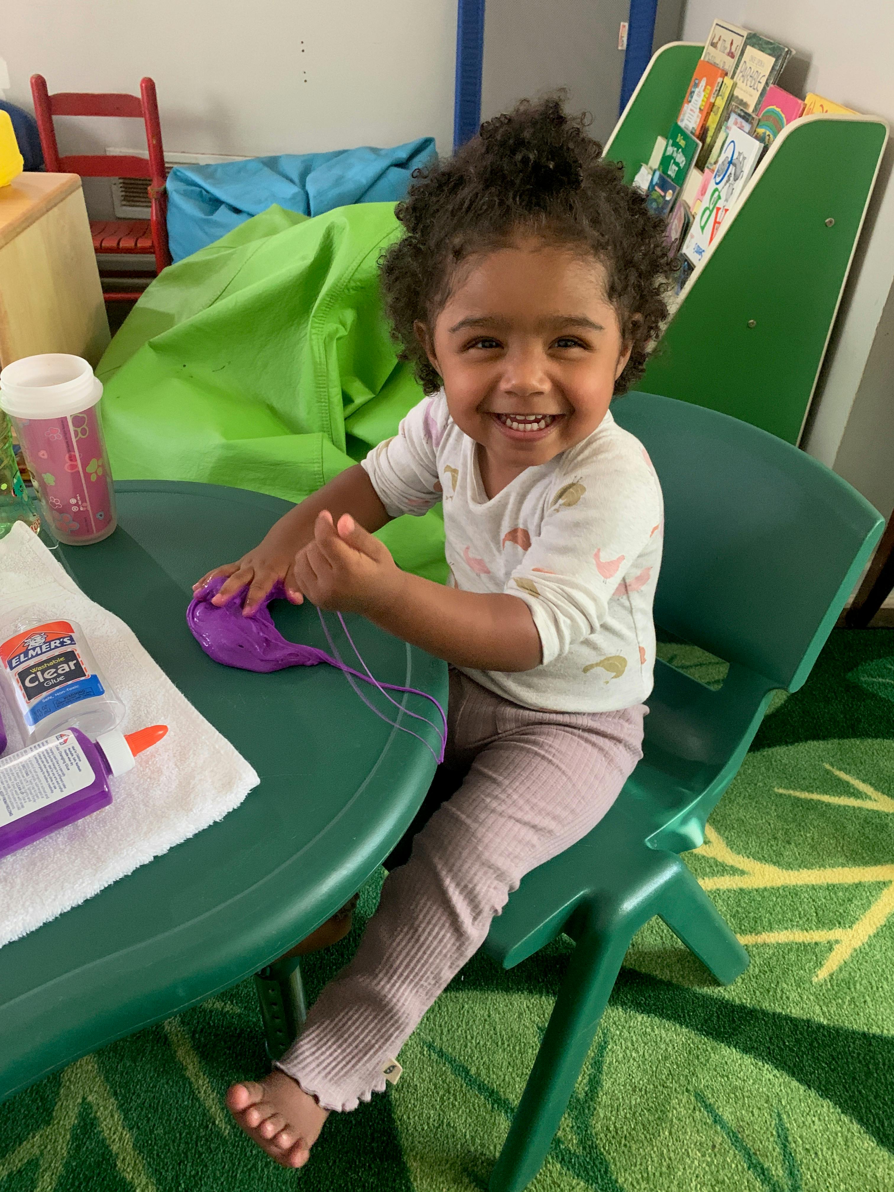 Child sitting at a table with craft supplies