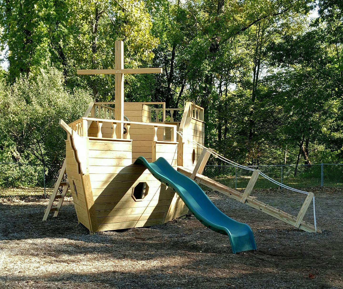 Wooden pirate ship playground with a blue slide