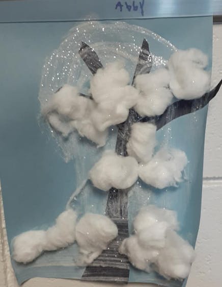 Tree craft with cotton balls and glitter on blue paper
