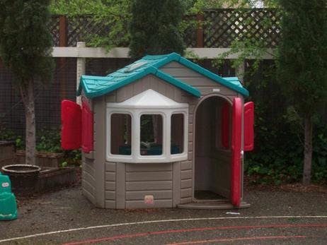 Playhouse with red shutters and teal roof