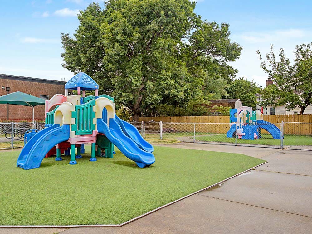 Playground with multiple slides on green turf