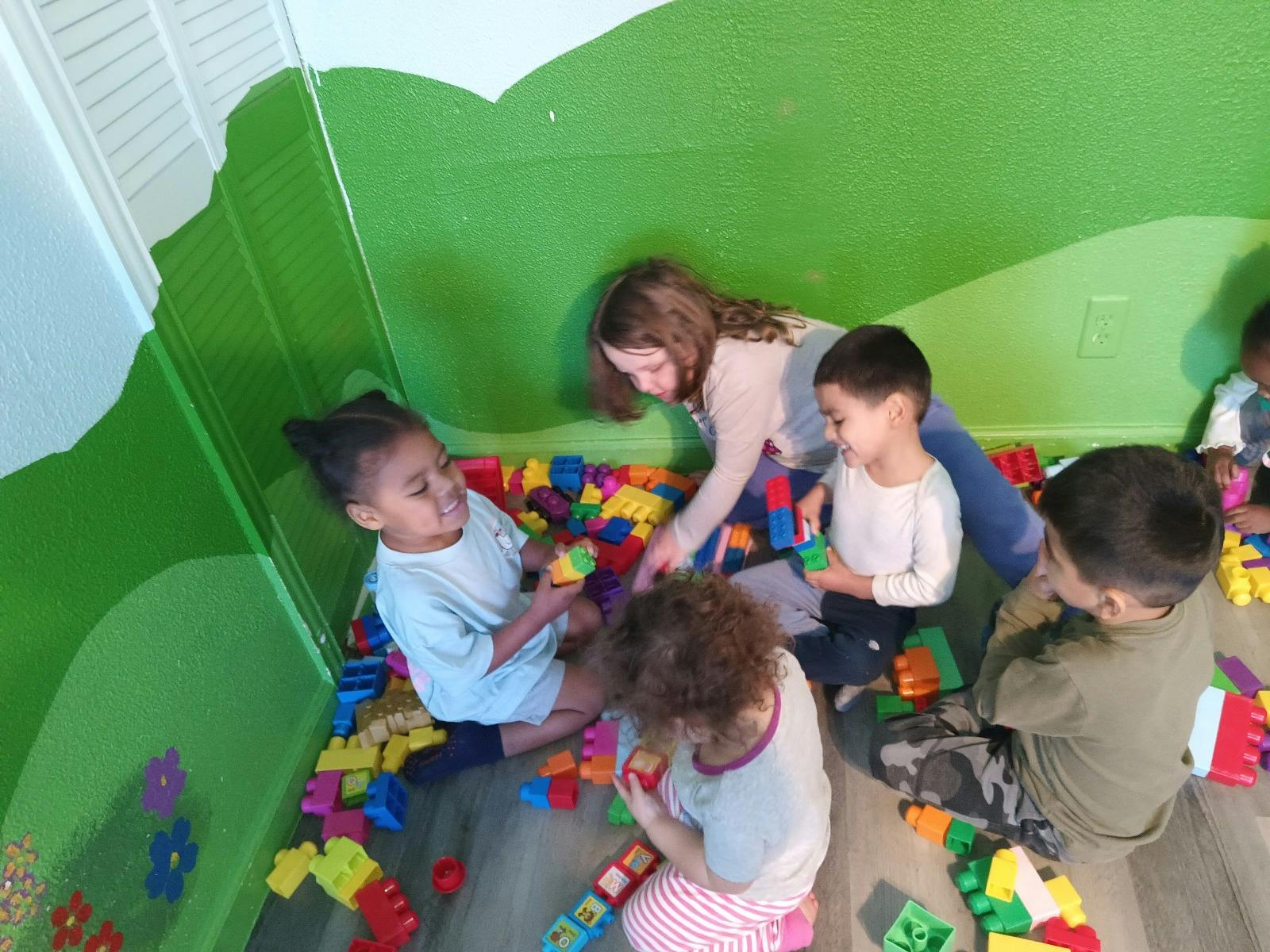 Adult and children playing with colorful building blocks
