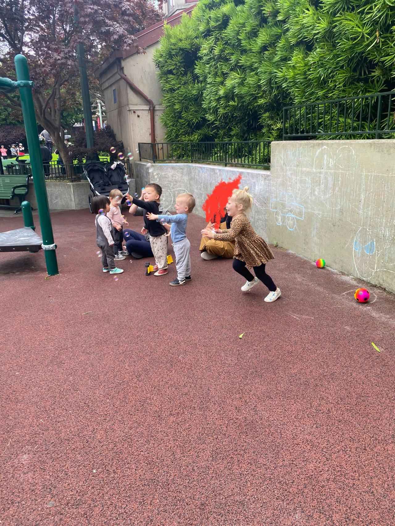 Children playing together on a red playground surface