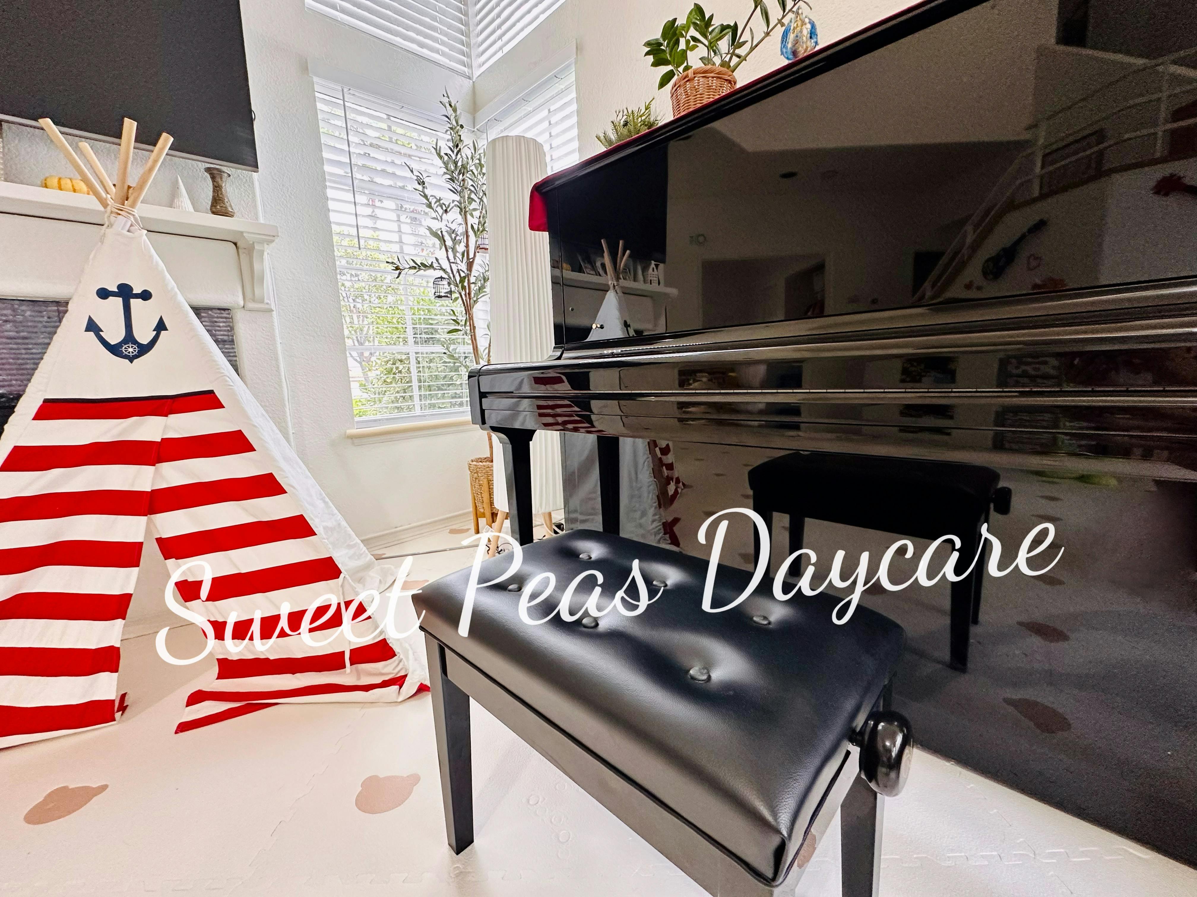 Play tent with red and white stripes next to a black piano