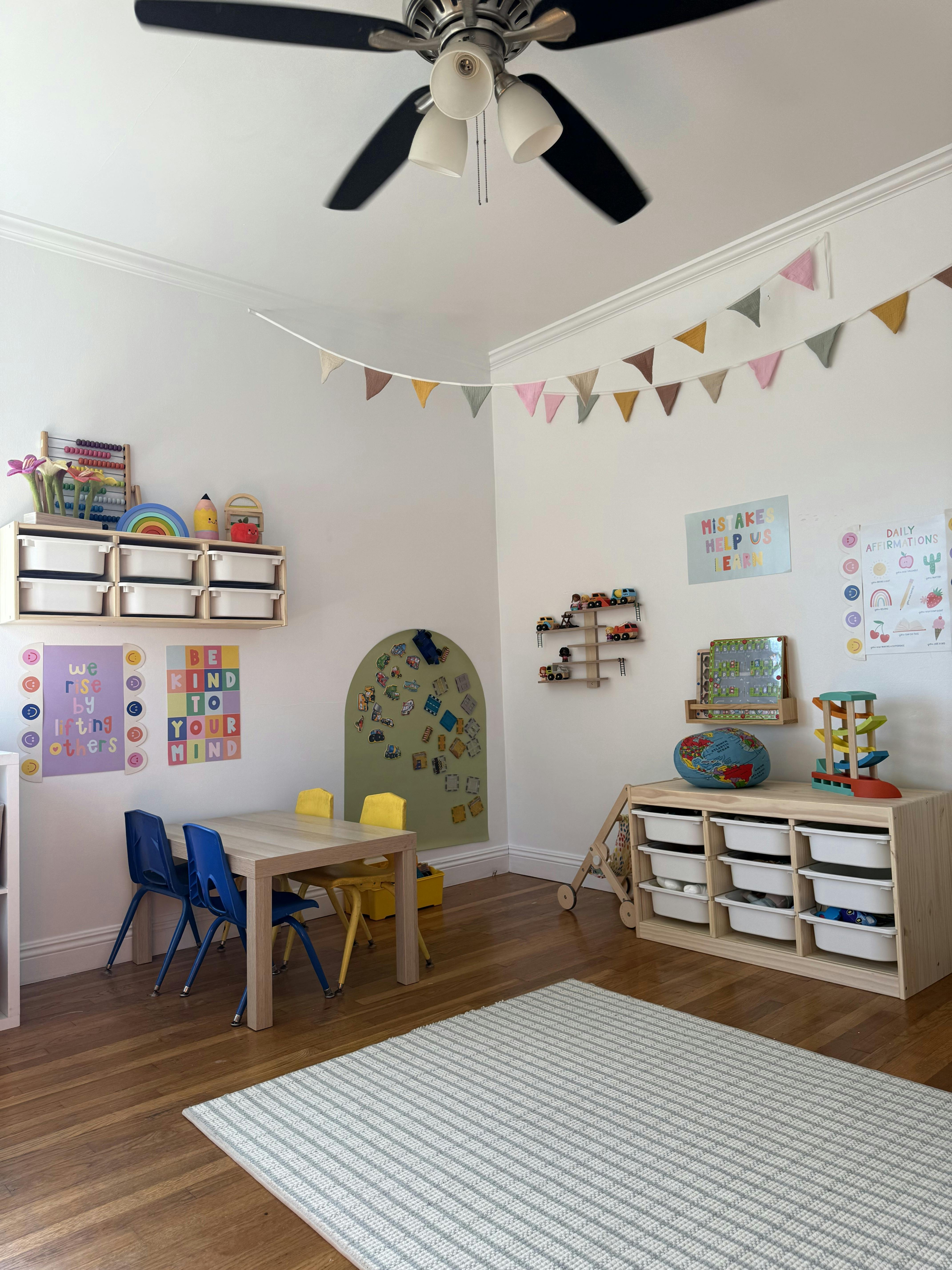 Children's play area with small table and chairs, storage, and decorations