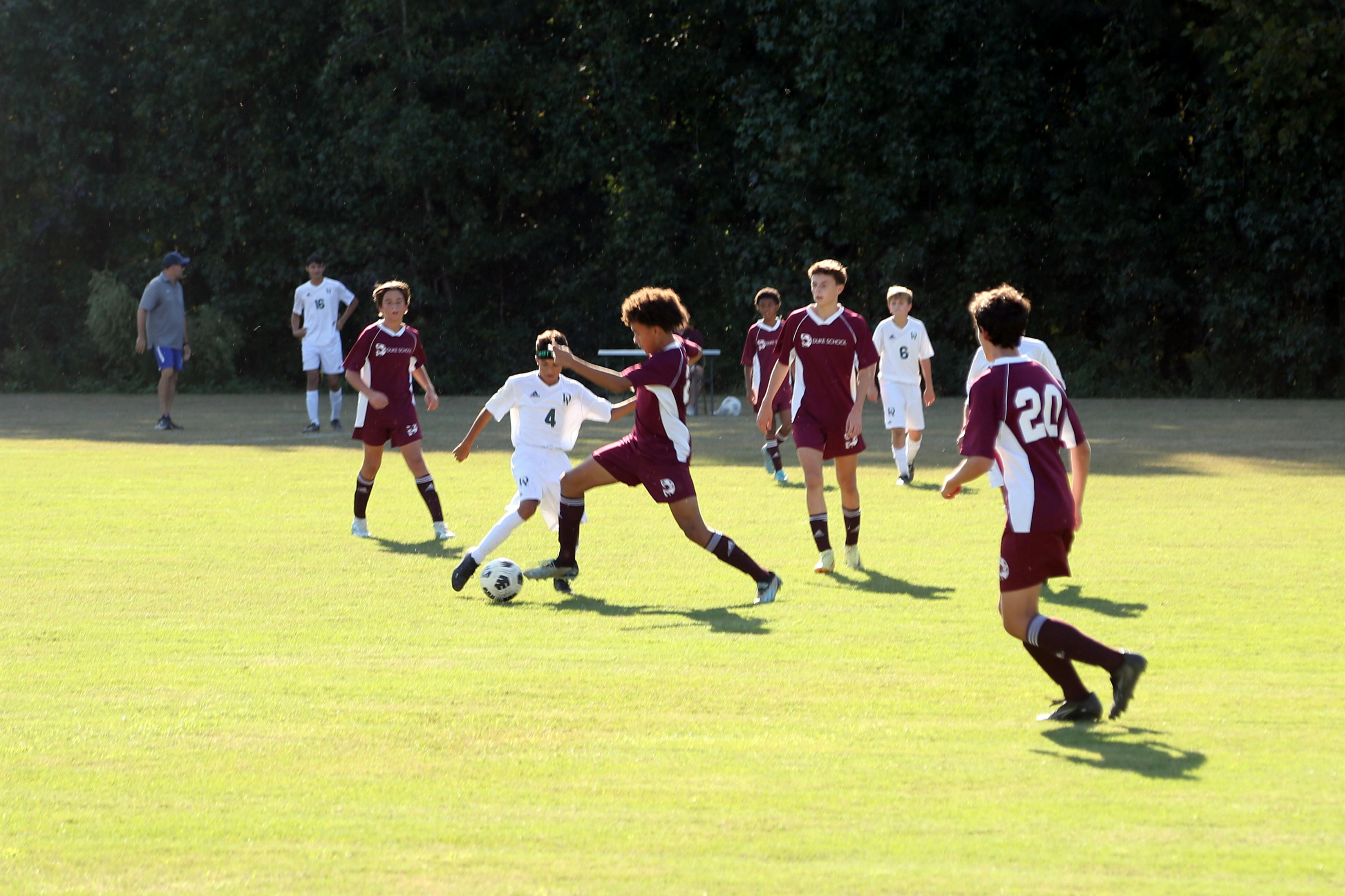 Teens playing soccer on a field