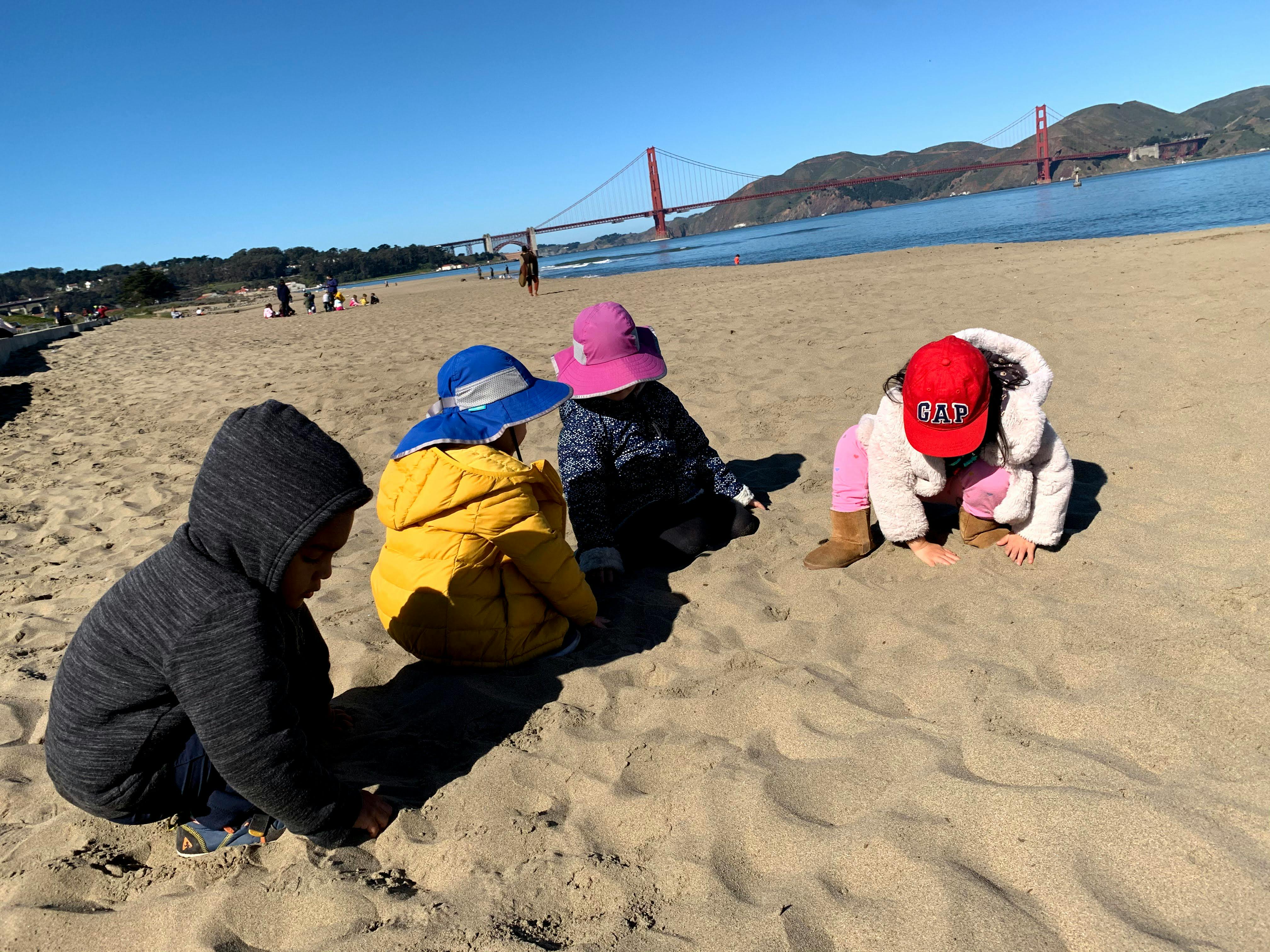 Four children playing on a sandy beach