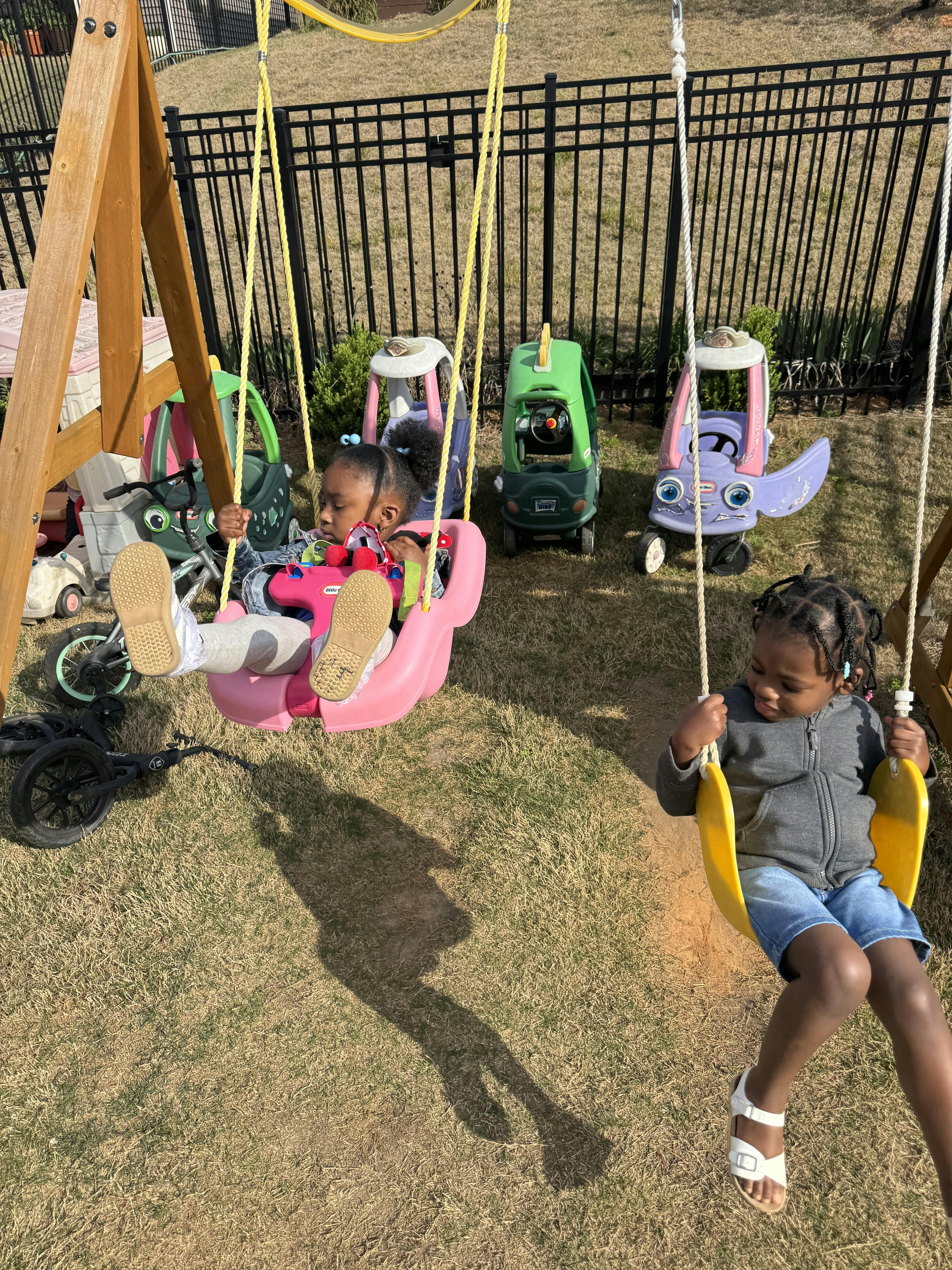 Two children swinging on a playground