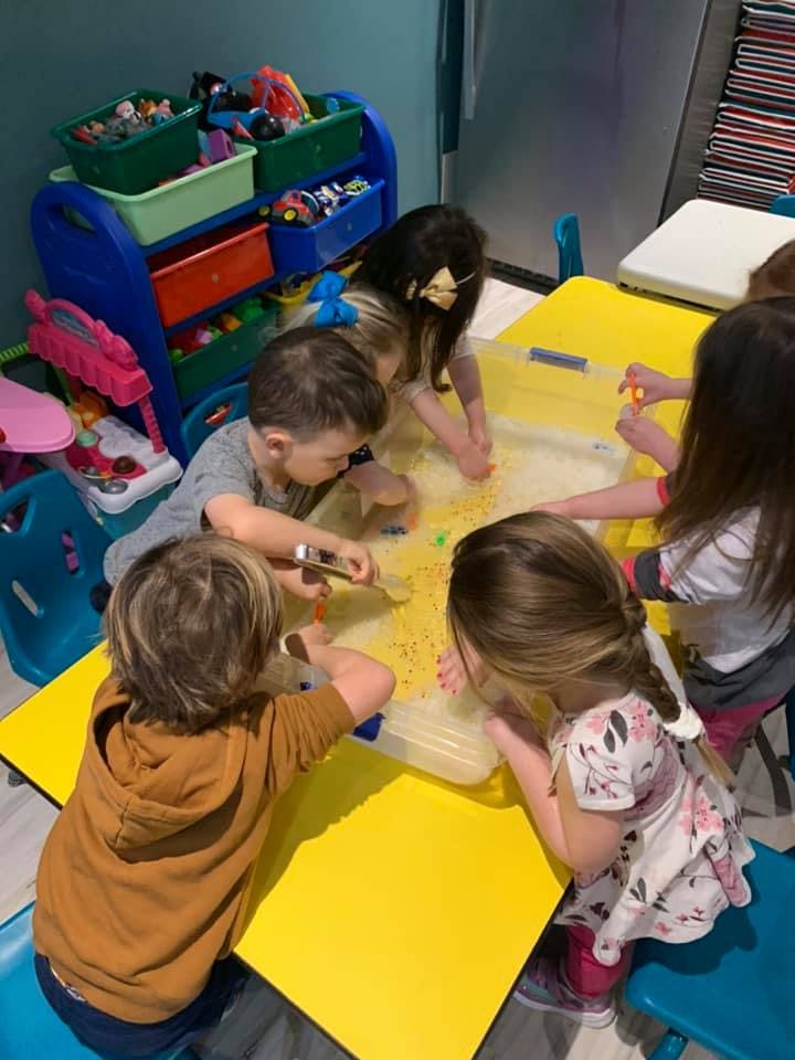 Children playing with sensory bin at a table