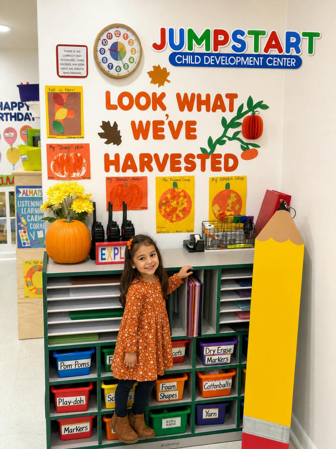 A child smiling in front of a colorful classroom storage cabinet