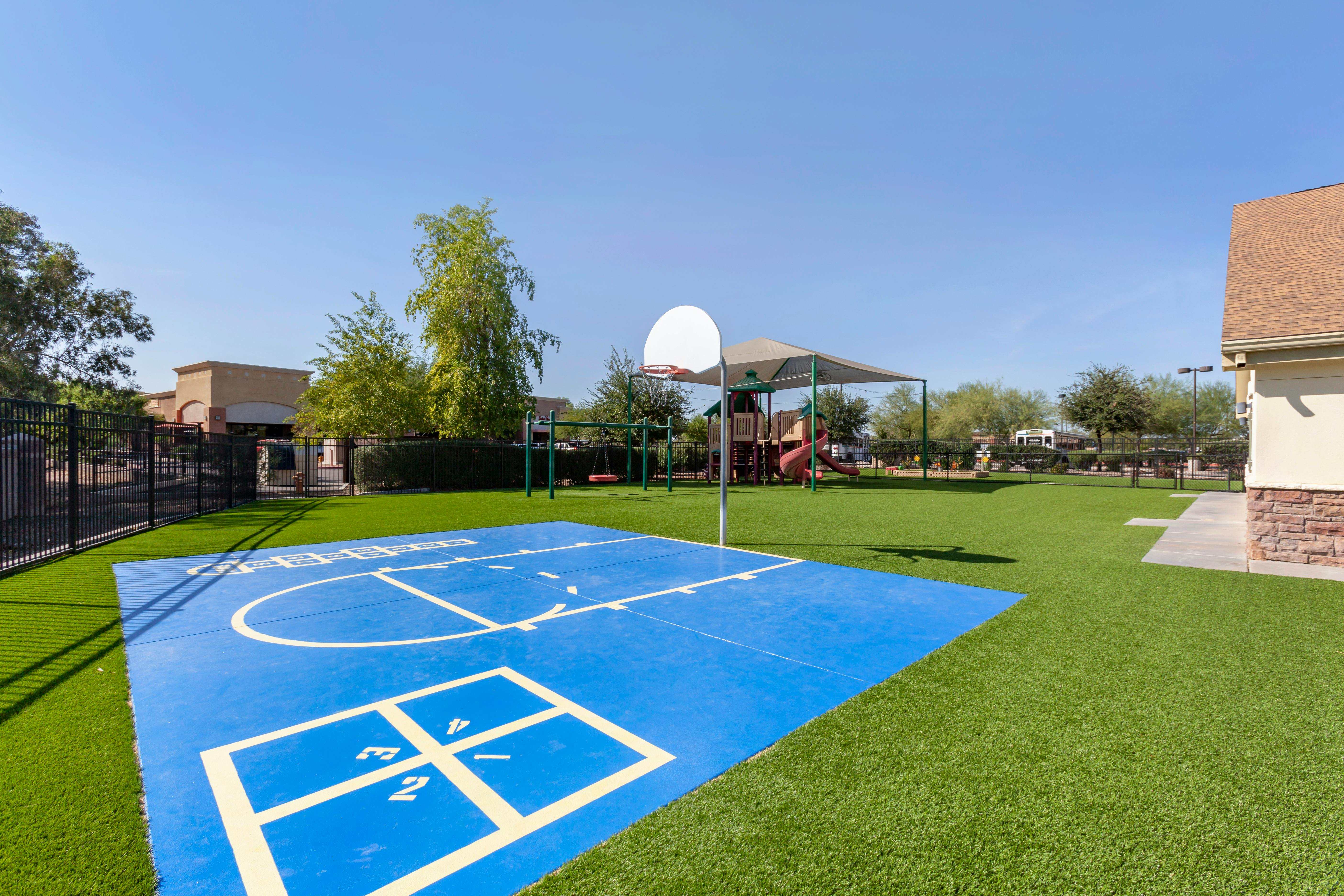 Blue court with white lines for basketball and hopscotch on artificial turf