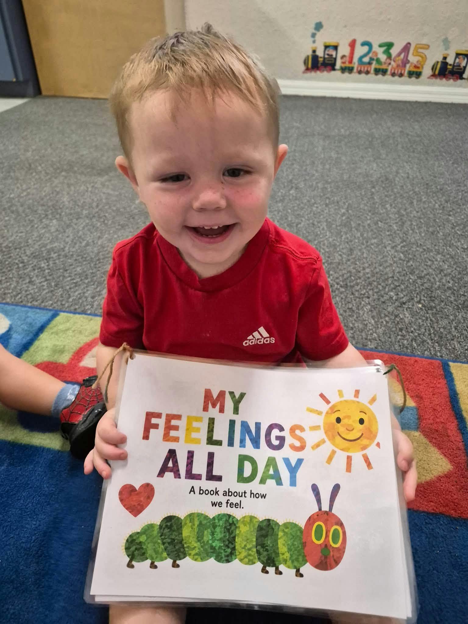 Child holding a book titled My Feelings All Day