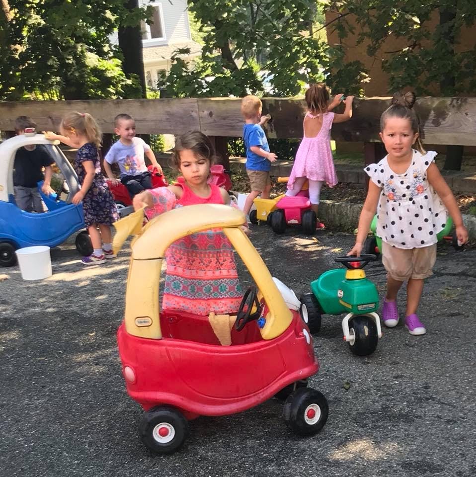 Children playing with ride-on toys outdoors