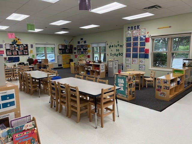 Classroom with child-sized tables and chairs, and learning materials
