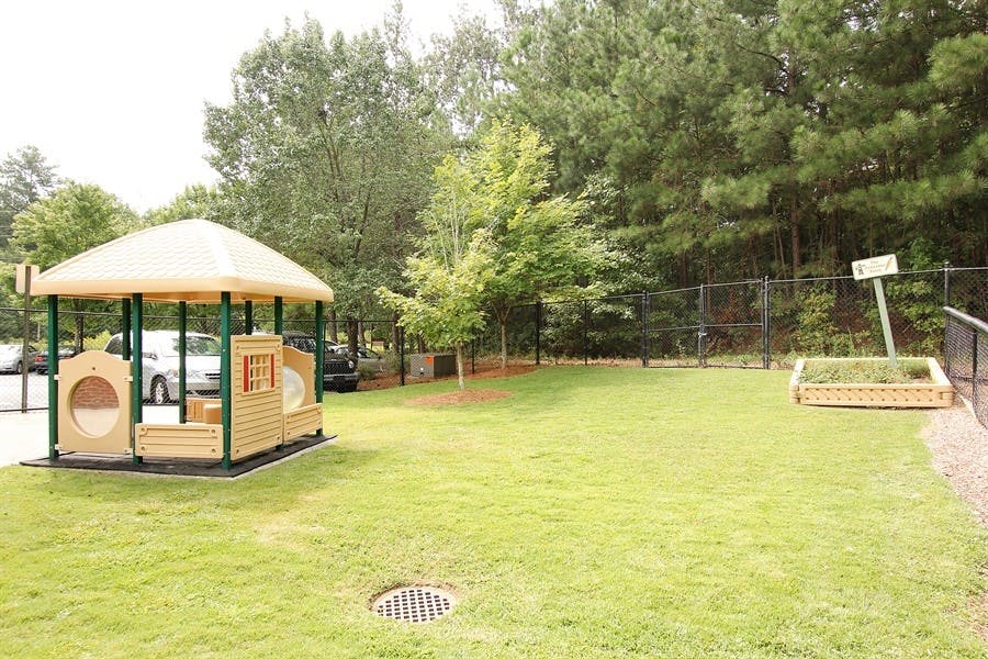Playground with a train-shaped play structure and a raised garden bed