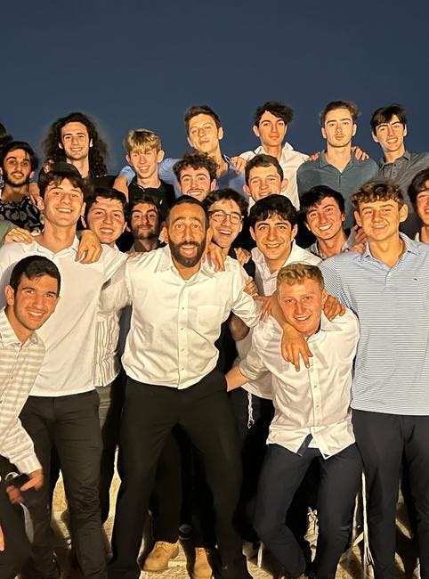 Group of young adult men standing together, smiling