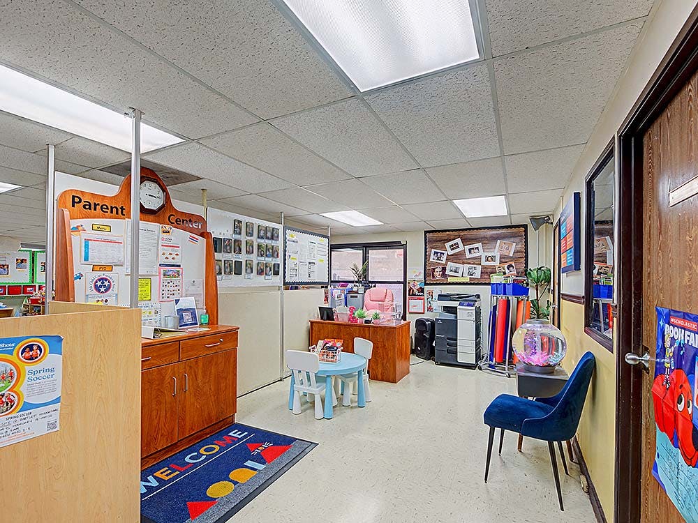 A room with a parent information center and child-sized table and chairs