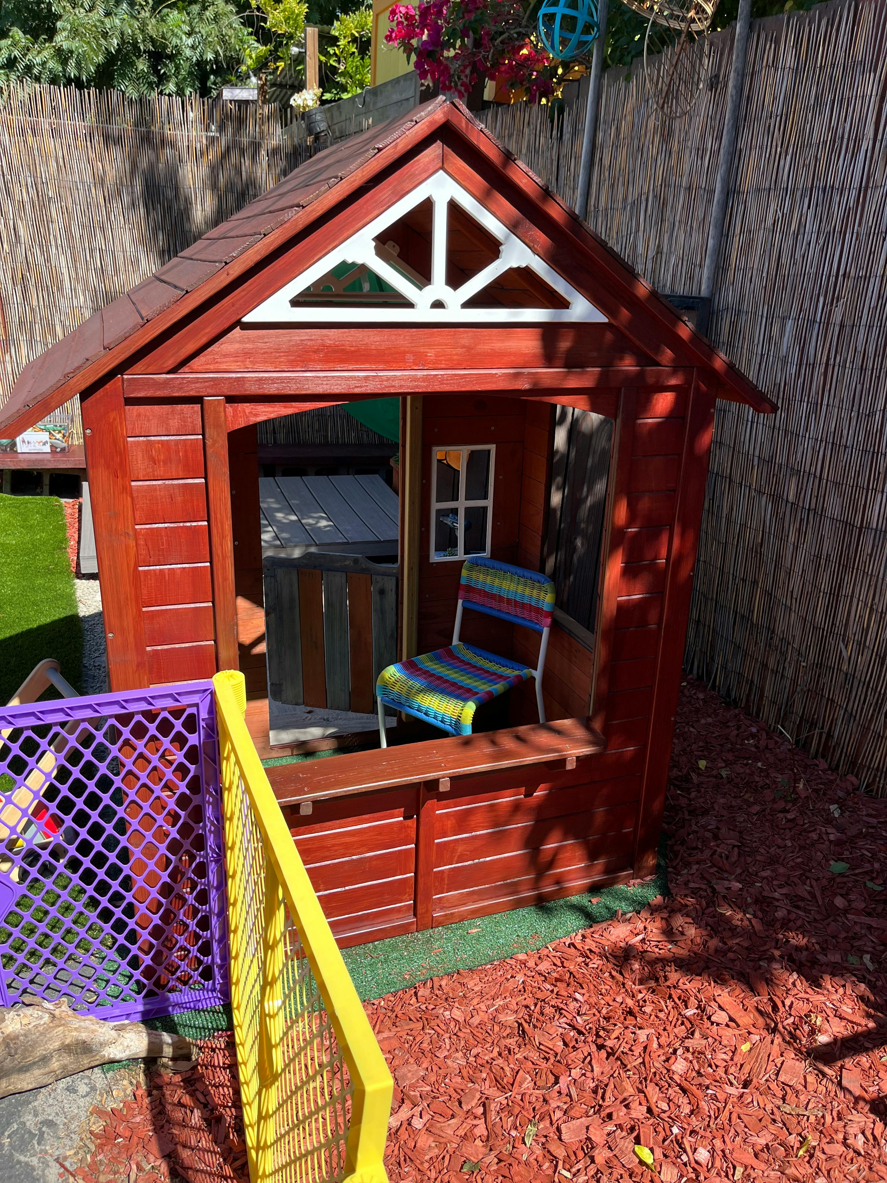 Wooden playhouse with a colorful chair inside
