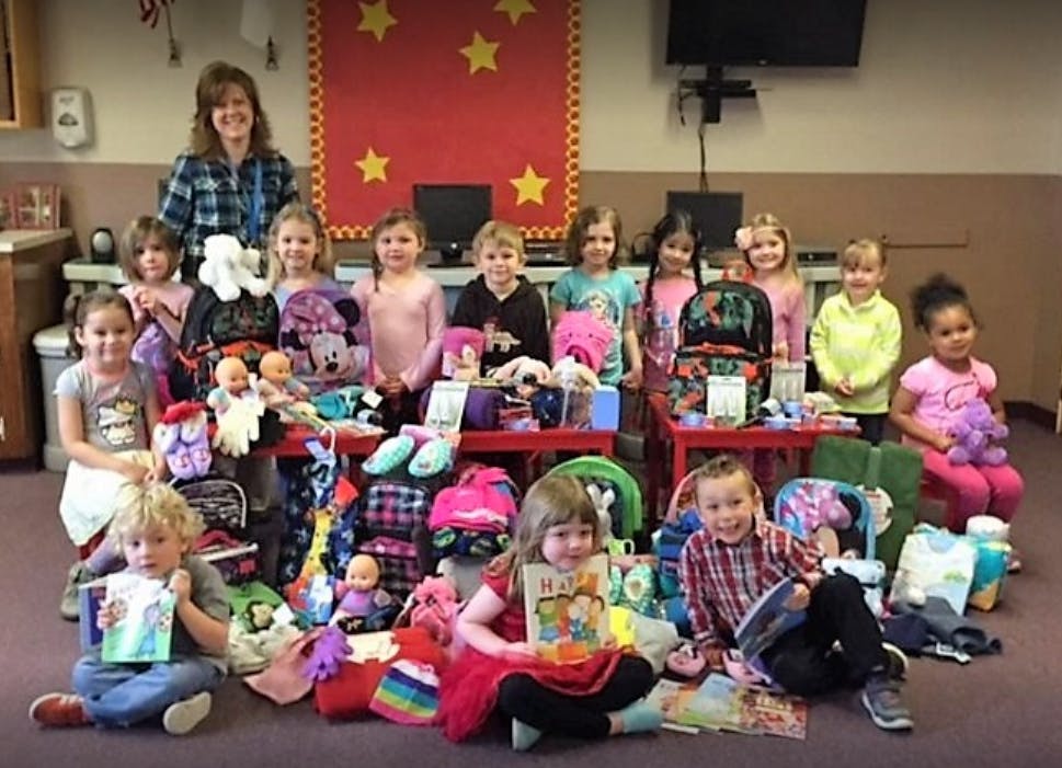 Adult and children posing with donated items