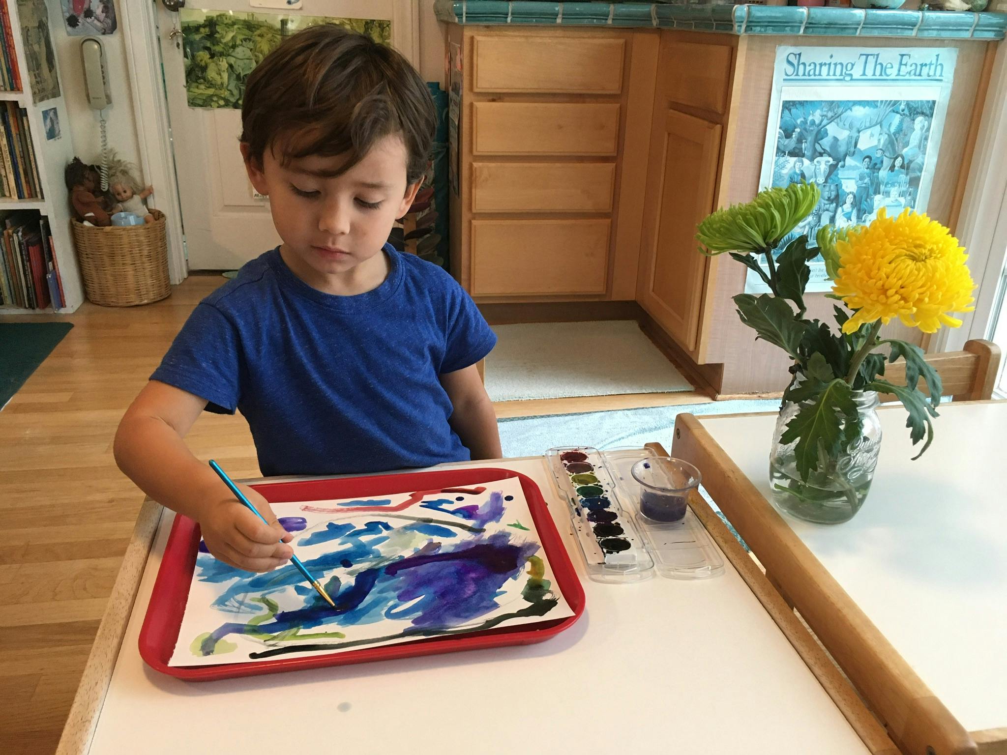 Child painting with watercolors at a table