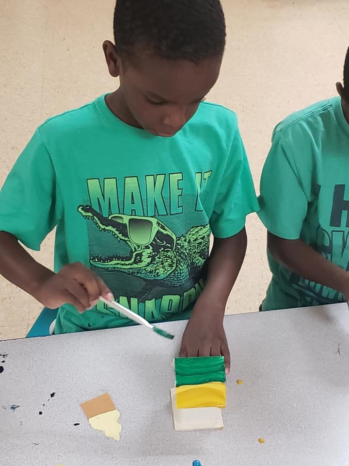 Child painting a block green