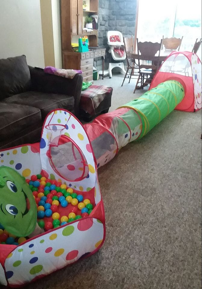 Play tunnel connecting a ball pit to a small tent