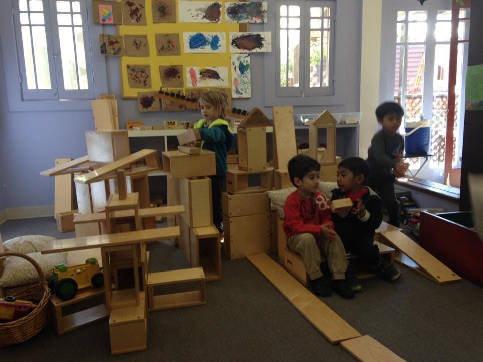 Children playing with wooden blocks in a classroom