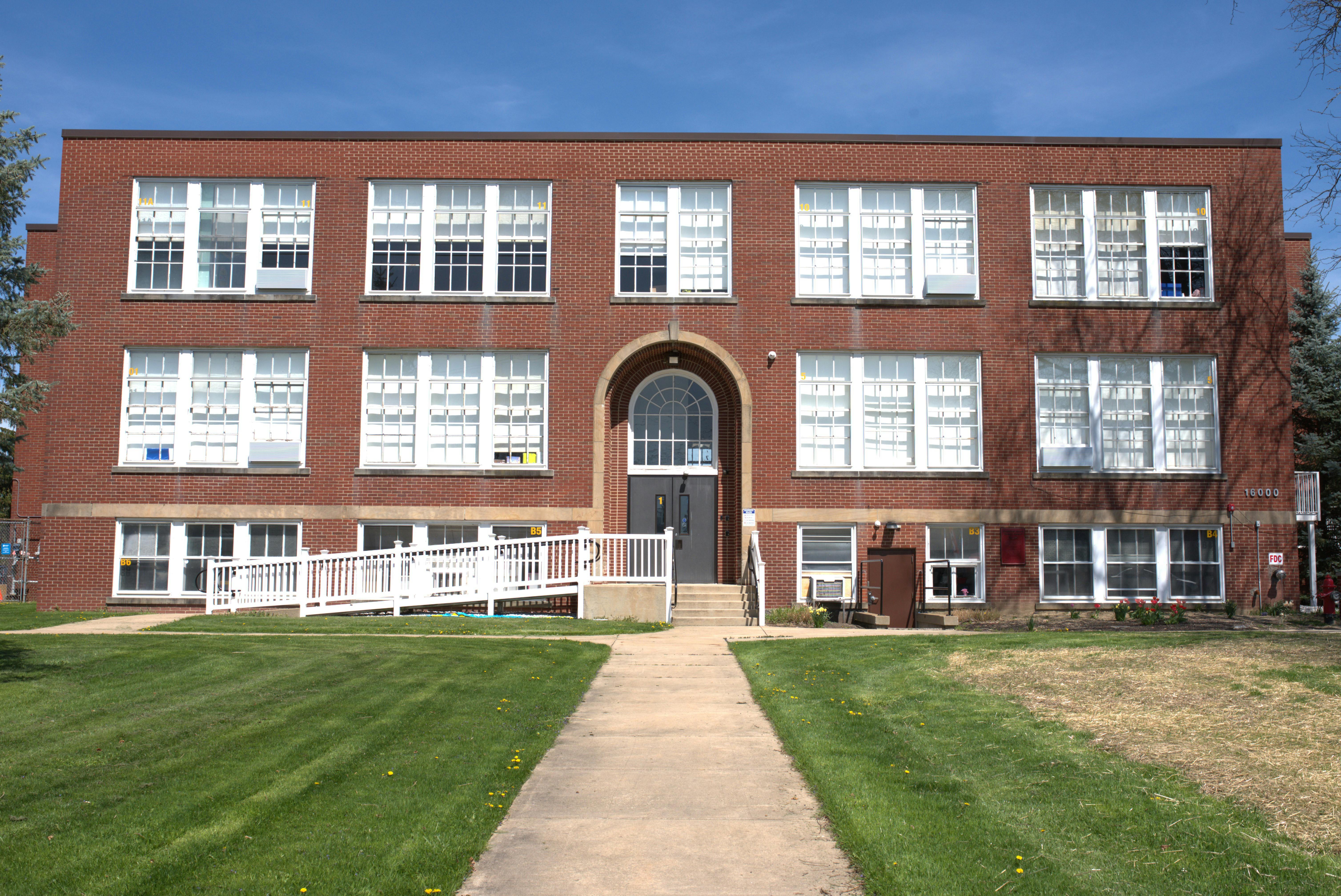 Brick building with multiple windows and a central arched entrance