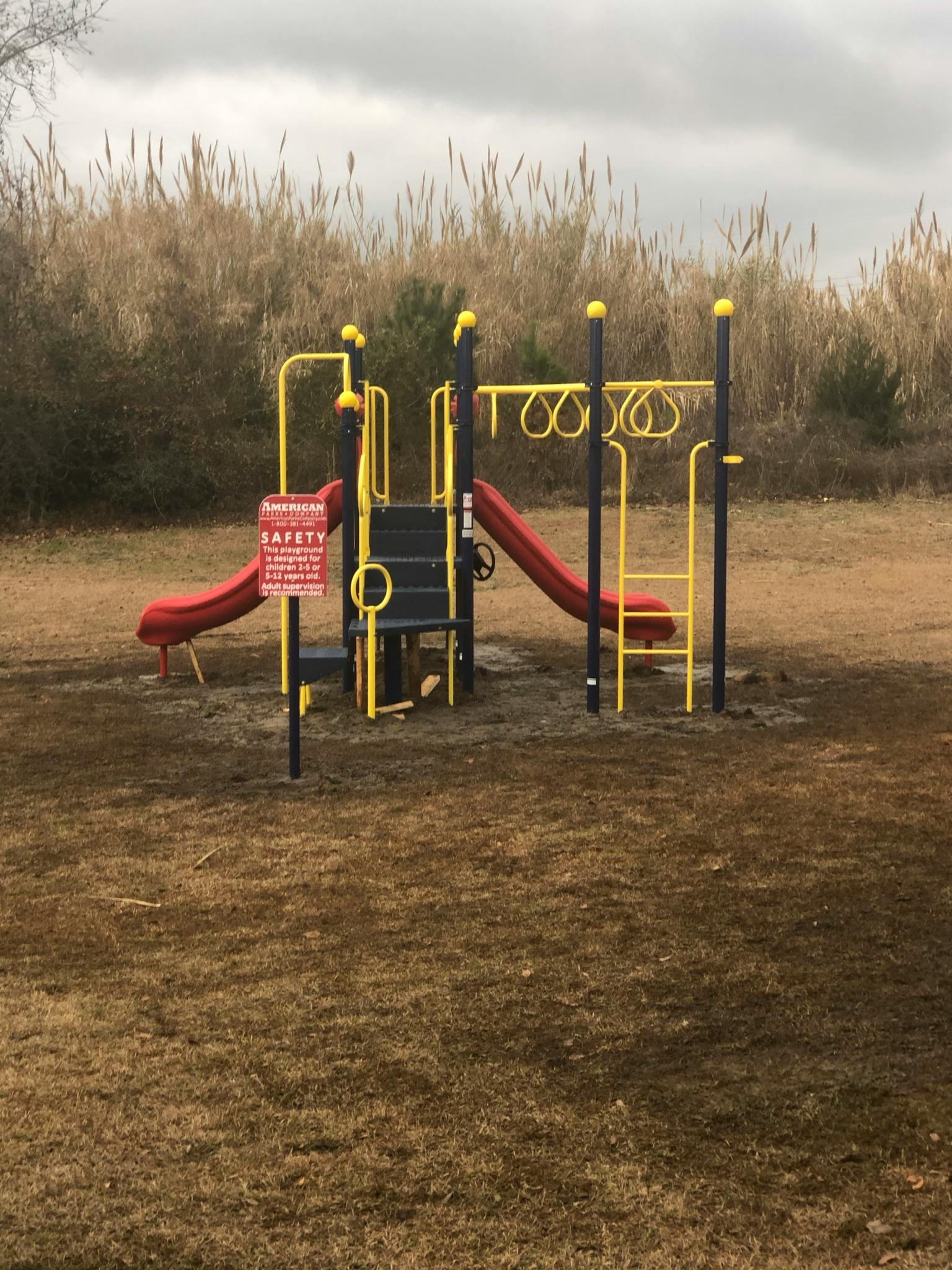 Playground with red slides and yellow climbing structures