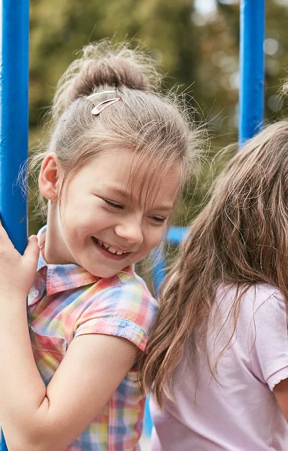 Child smiling next to another child