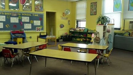 Empty classroom with small tables and chairs