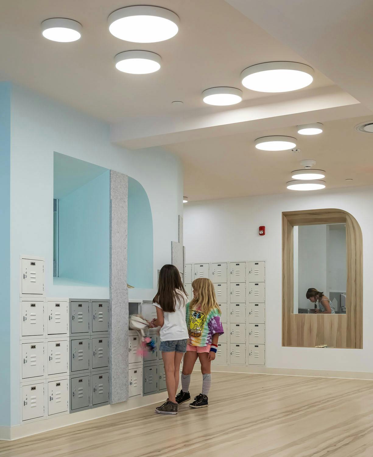 Two children standing by lockers