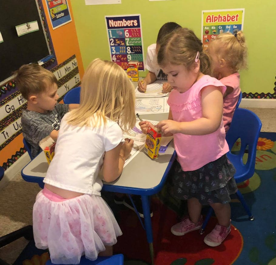 Children sitting at a table in a classroom