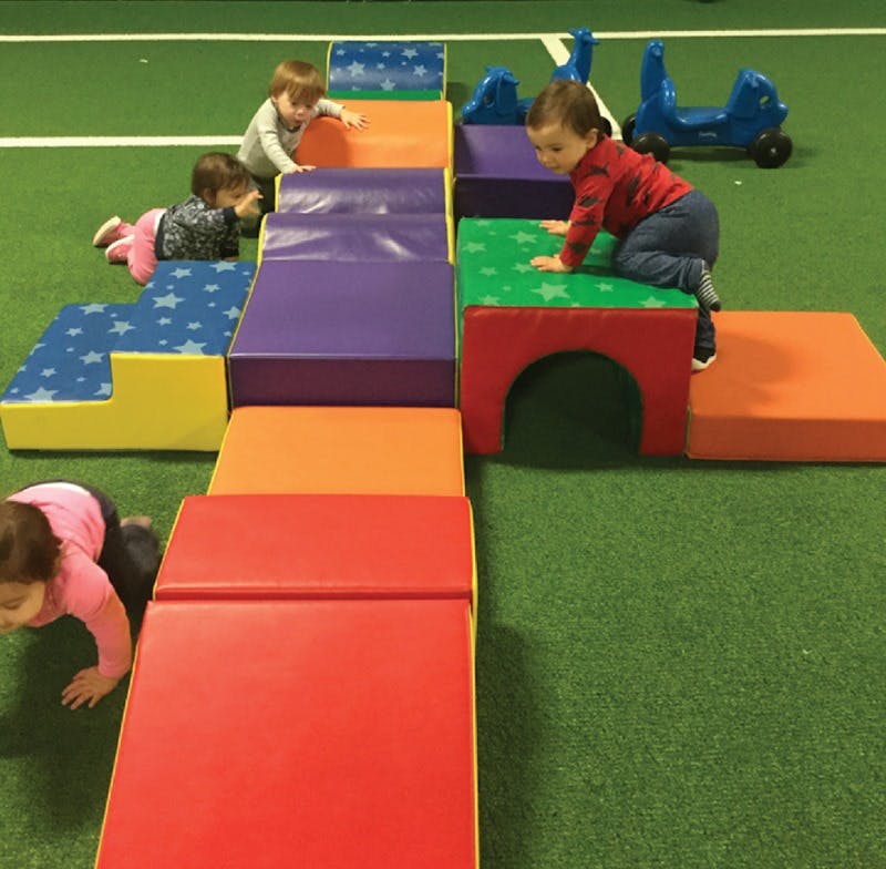 Children crawling and climbing on soft play equipment