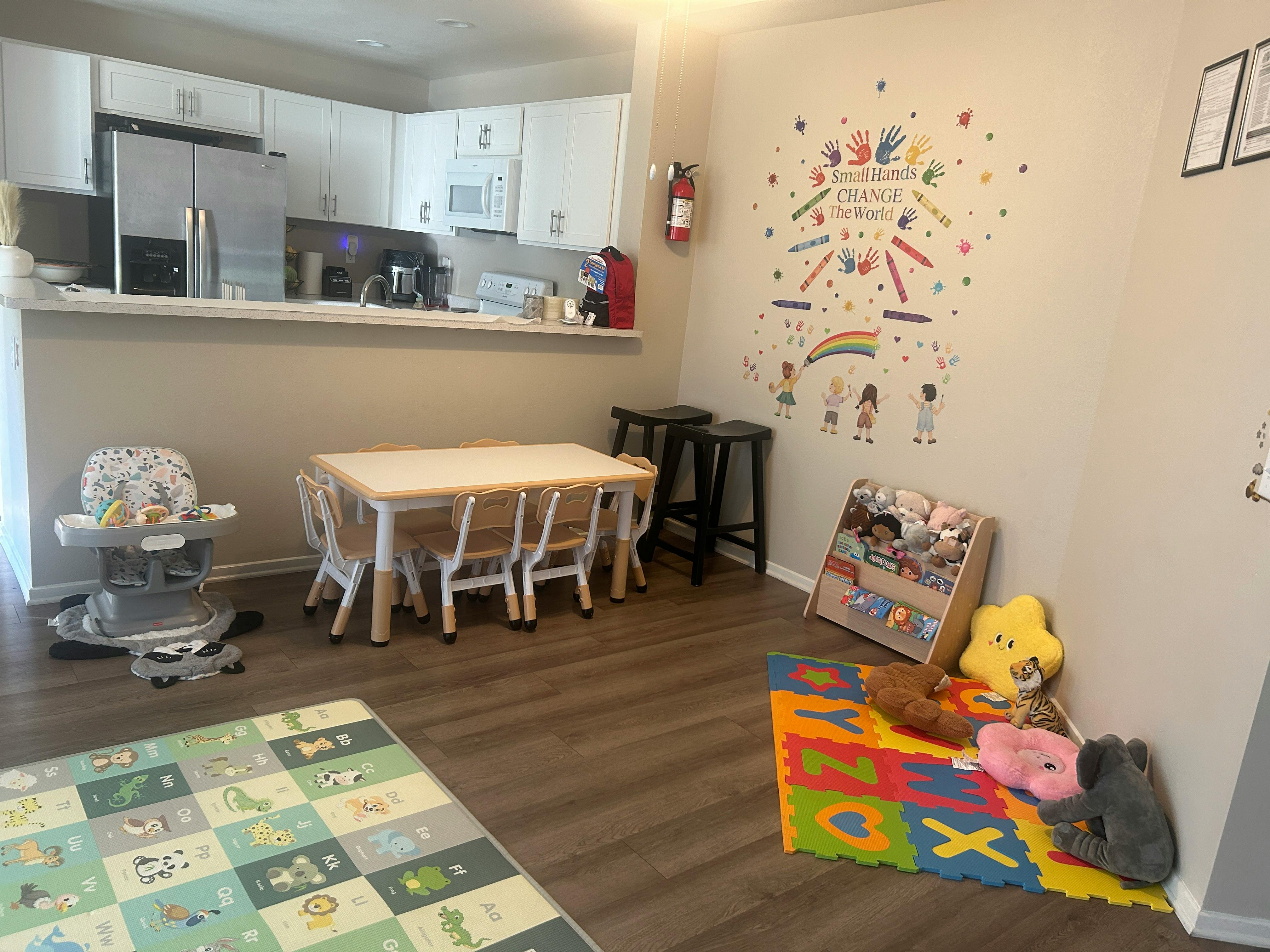 Playroom with a small table and chairs, high chair, and colorful rug