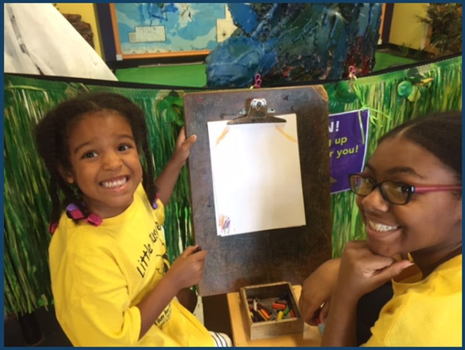 Child and teen next to a clipboard with blank paper
