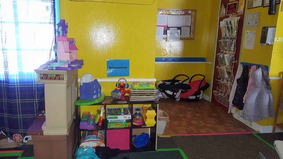 Playroom with toys on shelves and a window with blue curtains