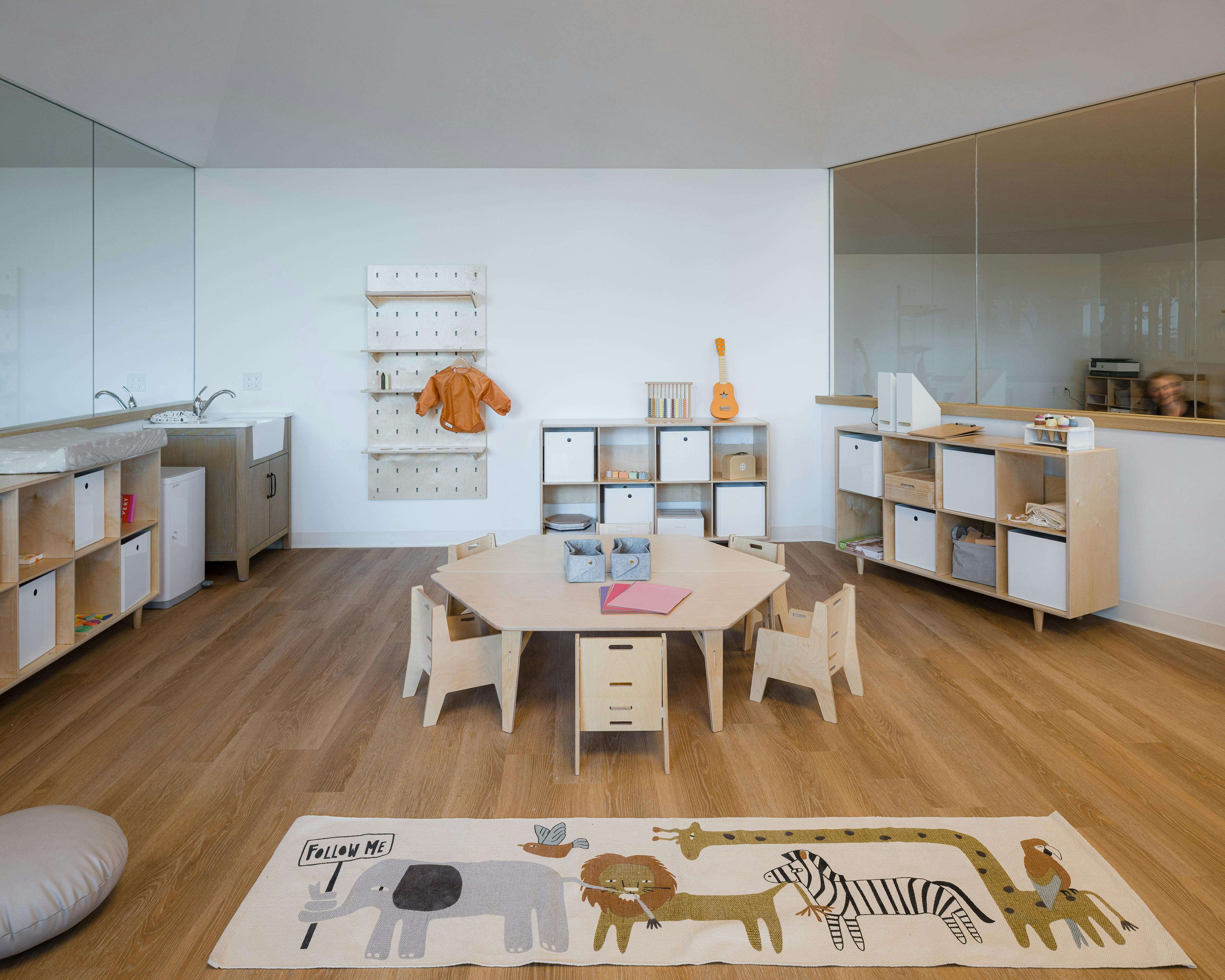 Playroom with small table and chairs, shelves, and animal print rug