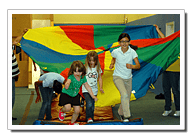 Children and adults playing with a colorful parachute