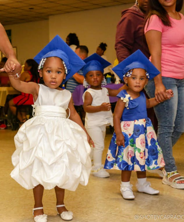 Three children in graduation caps and formal wear