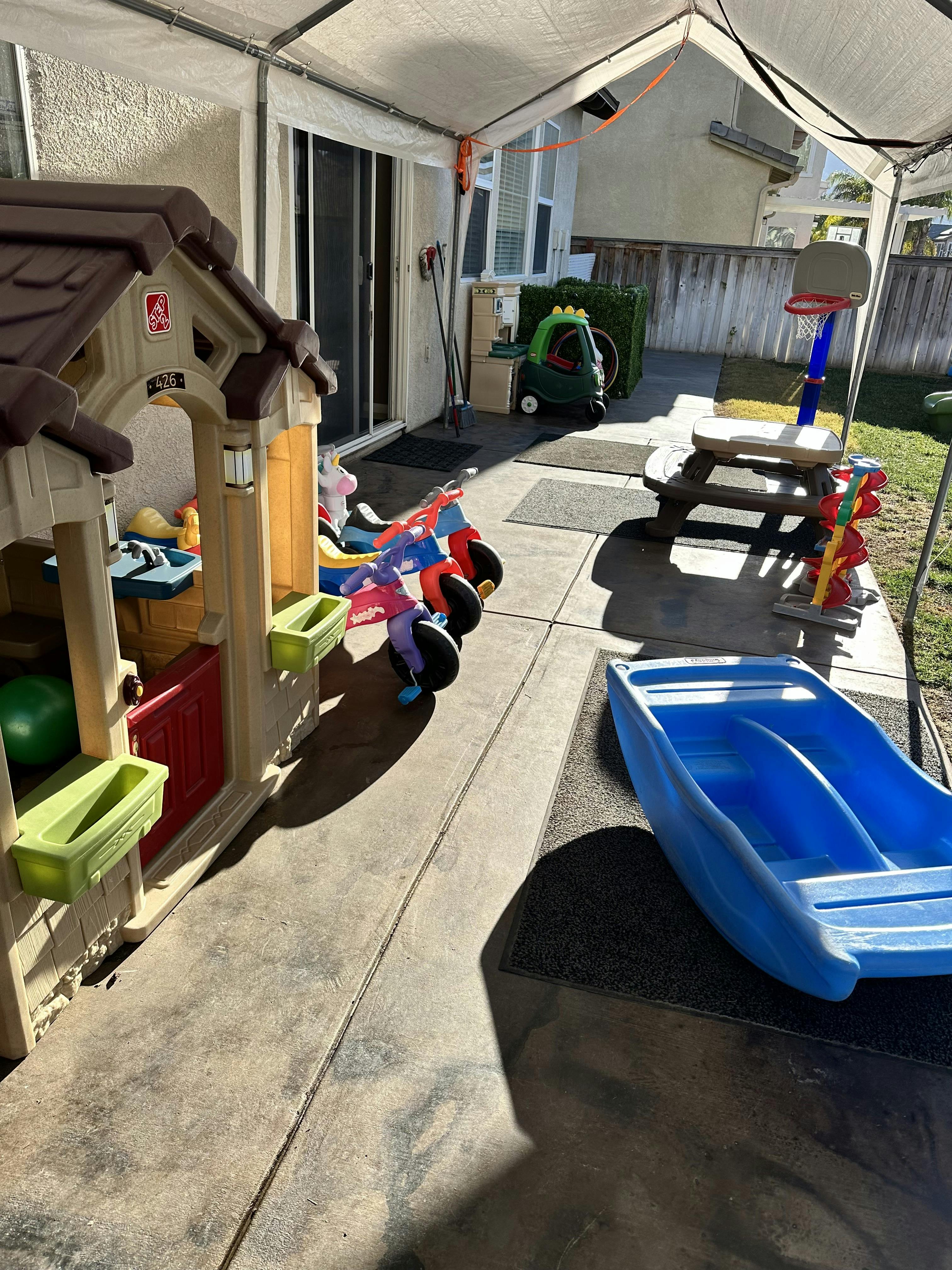 Patio with a children's playhouse, tricycle, and other toys