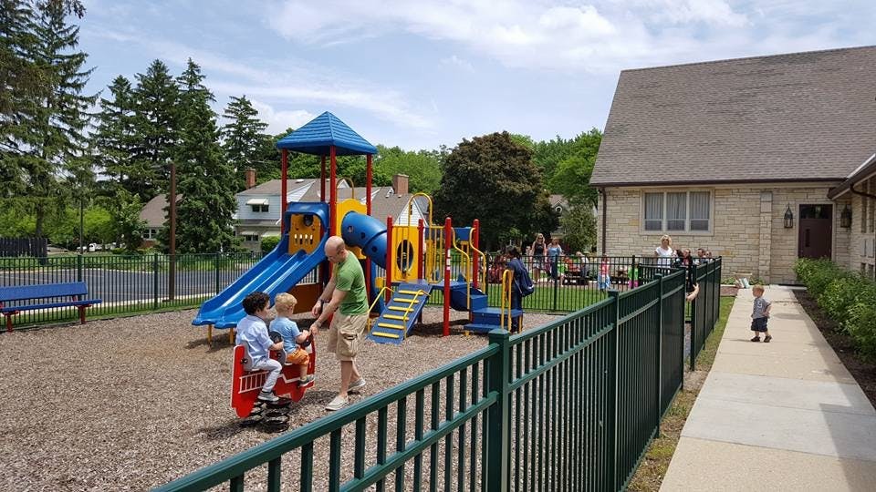 Person with children on a playground with slides and swings