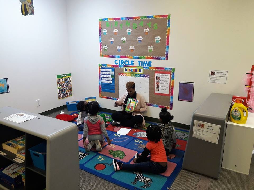 Person reading to children during circle time in a classroom