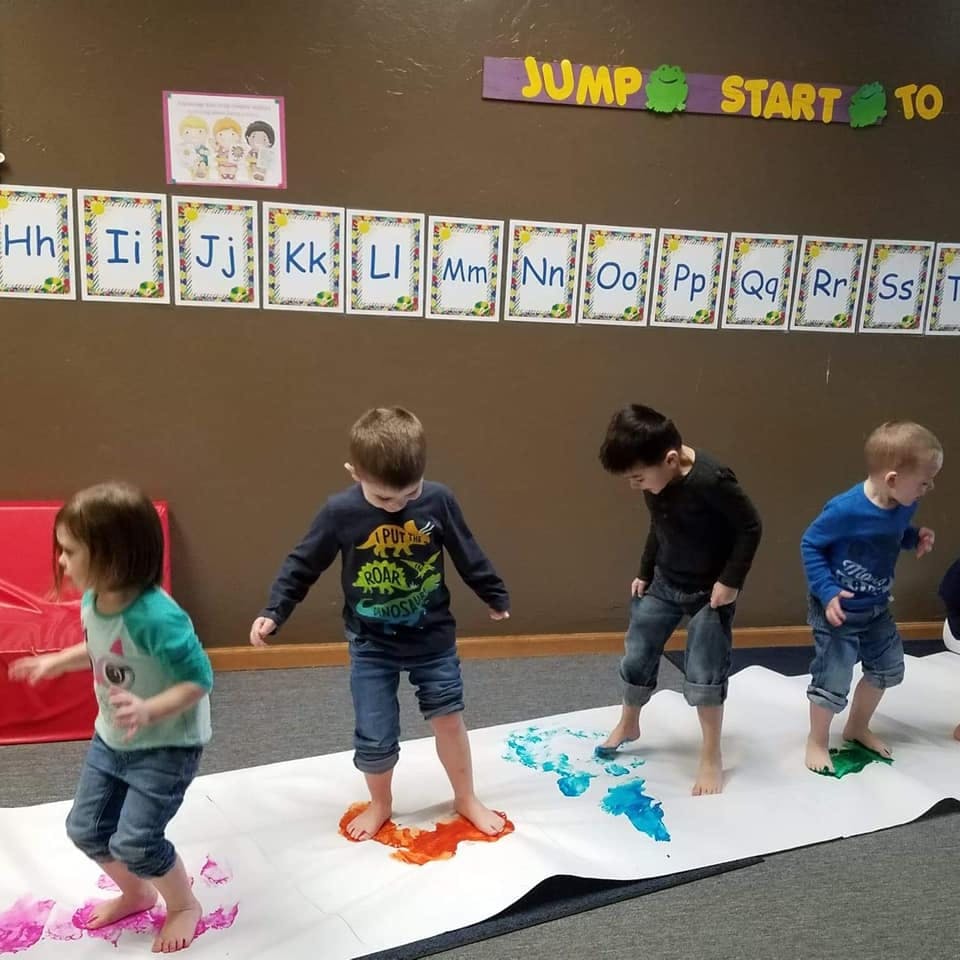 Children doing foot painting in a classroom